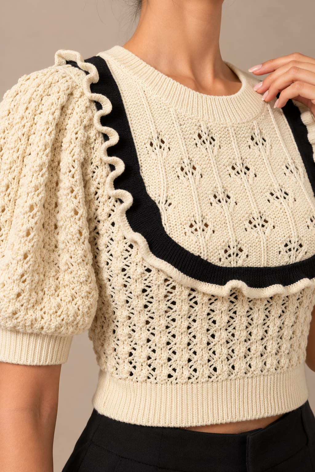 Close view of the pointelle stitch, ric-rac trim and black bib outline
