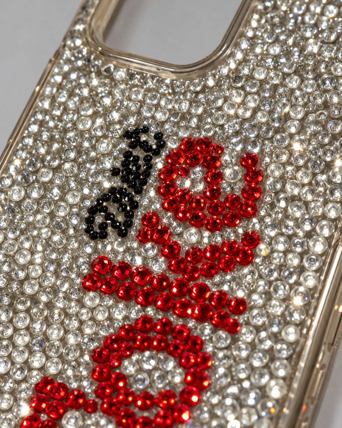 Close-up of crystal and red rhinestone lettering