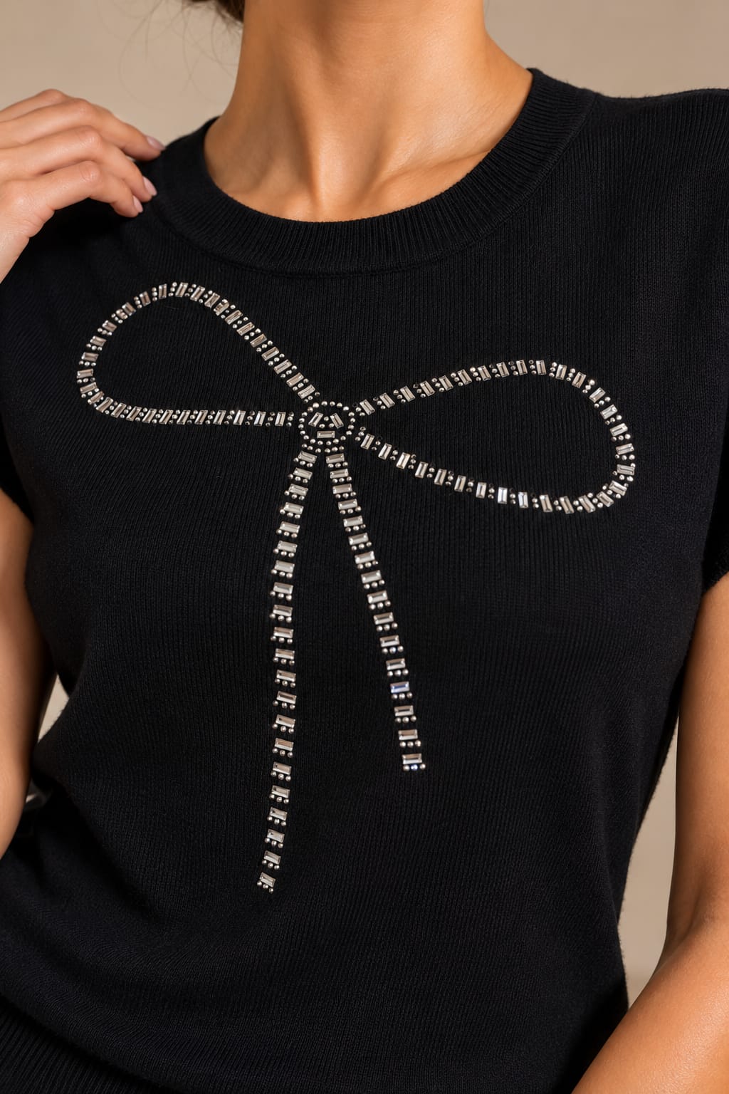 Close view of the bow worked in silver baguette stones and round beads