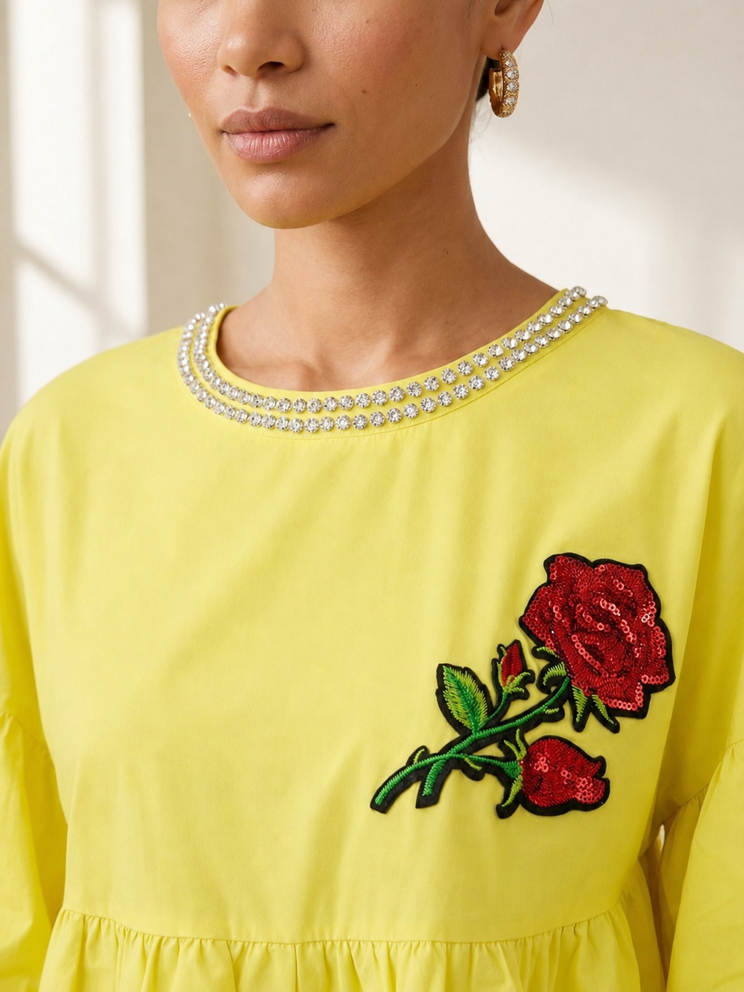 Close detail of the crystal-trimmed neckline and sequinned rose applique